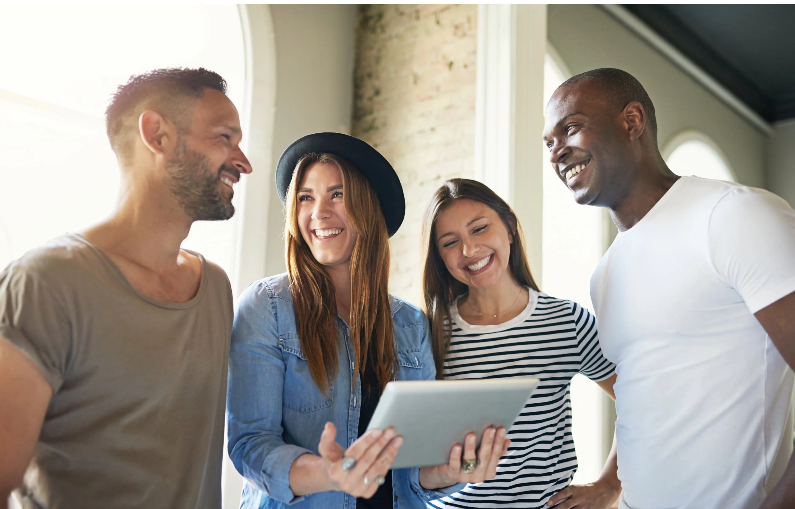 four people smiling around an iPad